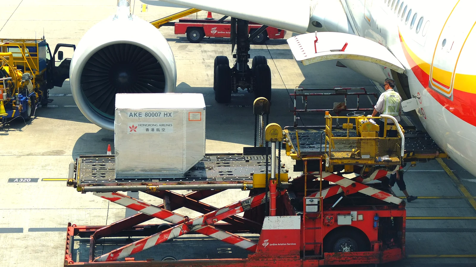 ULD air cargo container lifted by a scissor loader to the hold of a passenger aircraft