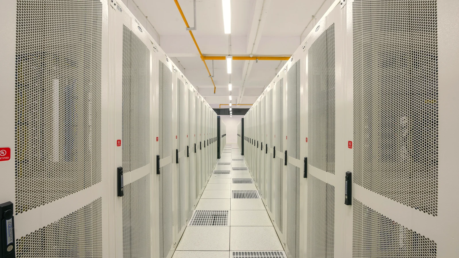 Long aisle of white server racks in a data centre