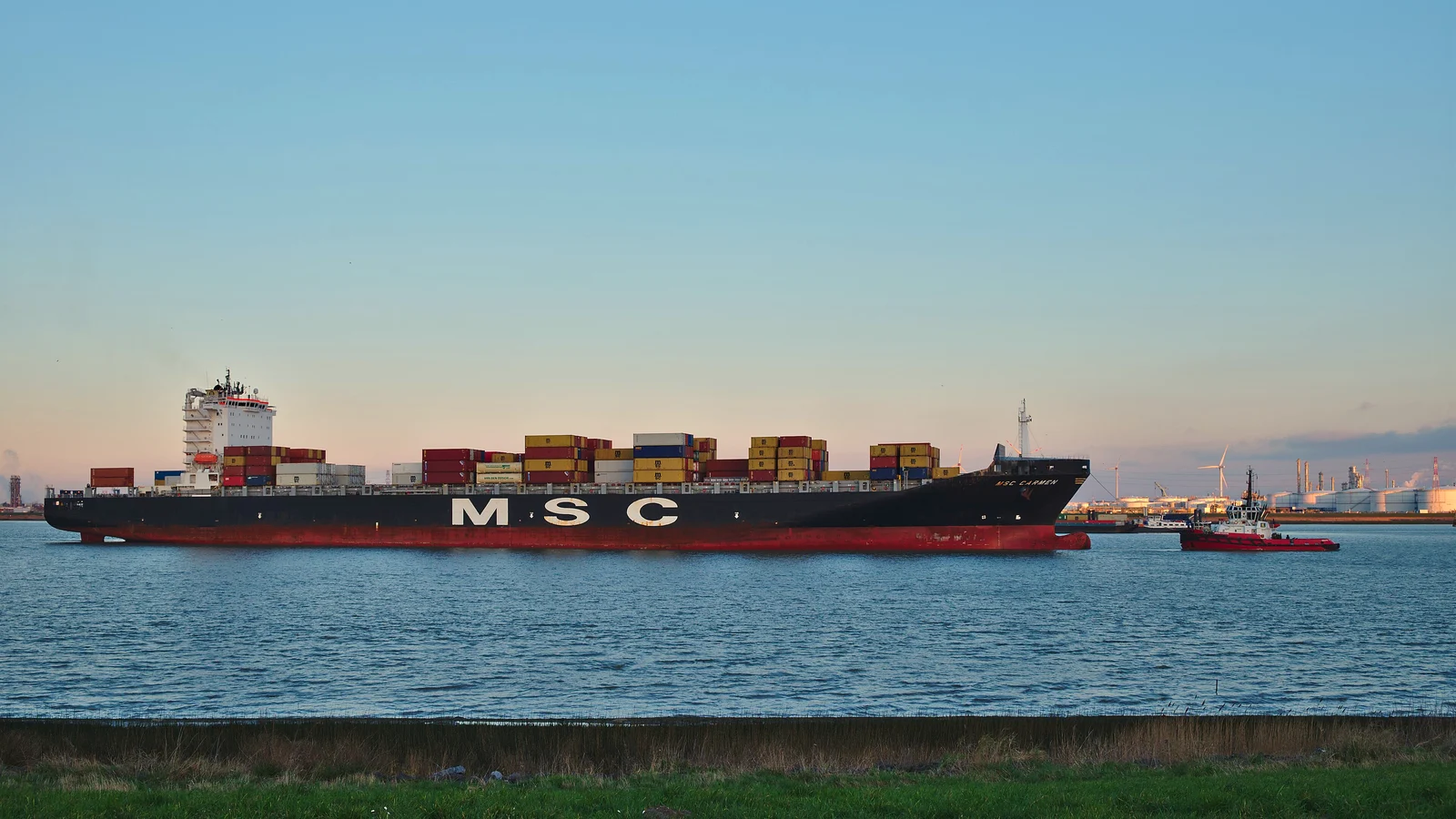 MSC container ship with a tug on the Scheldt river heading to the Port of Antwerp