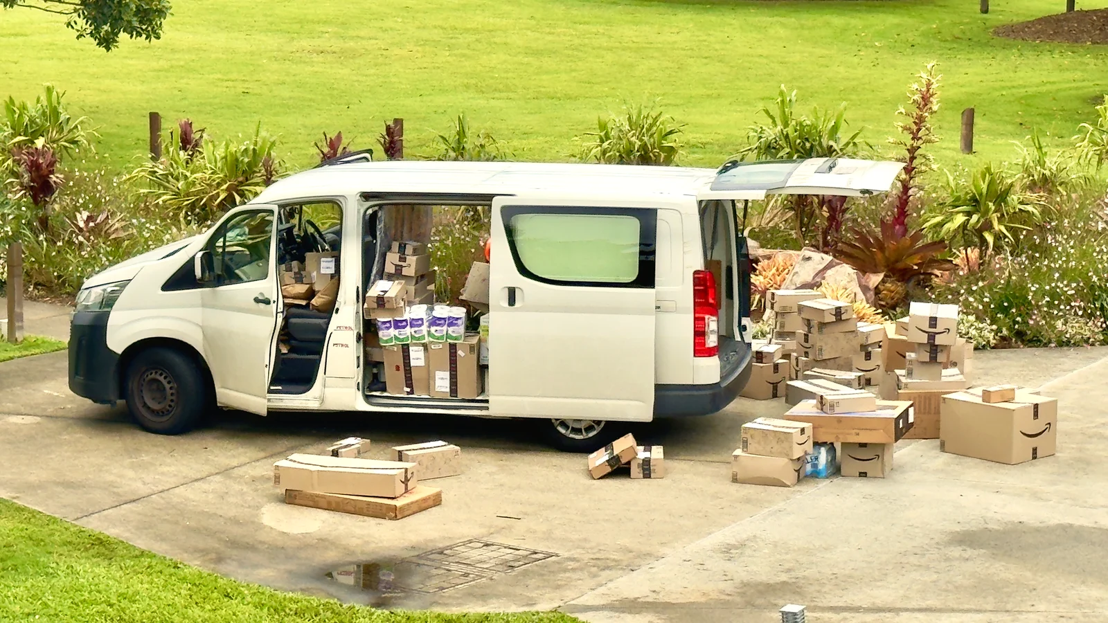 Delivery van unloaded with parcels and boxes stacked beside it