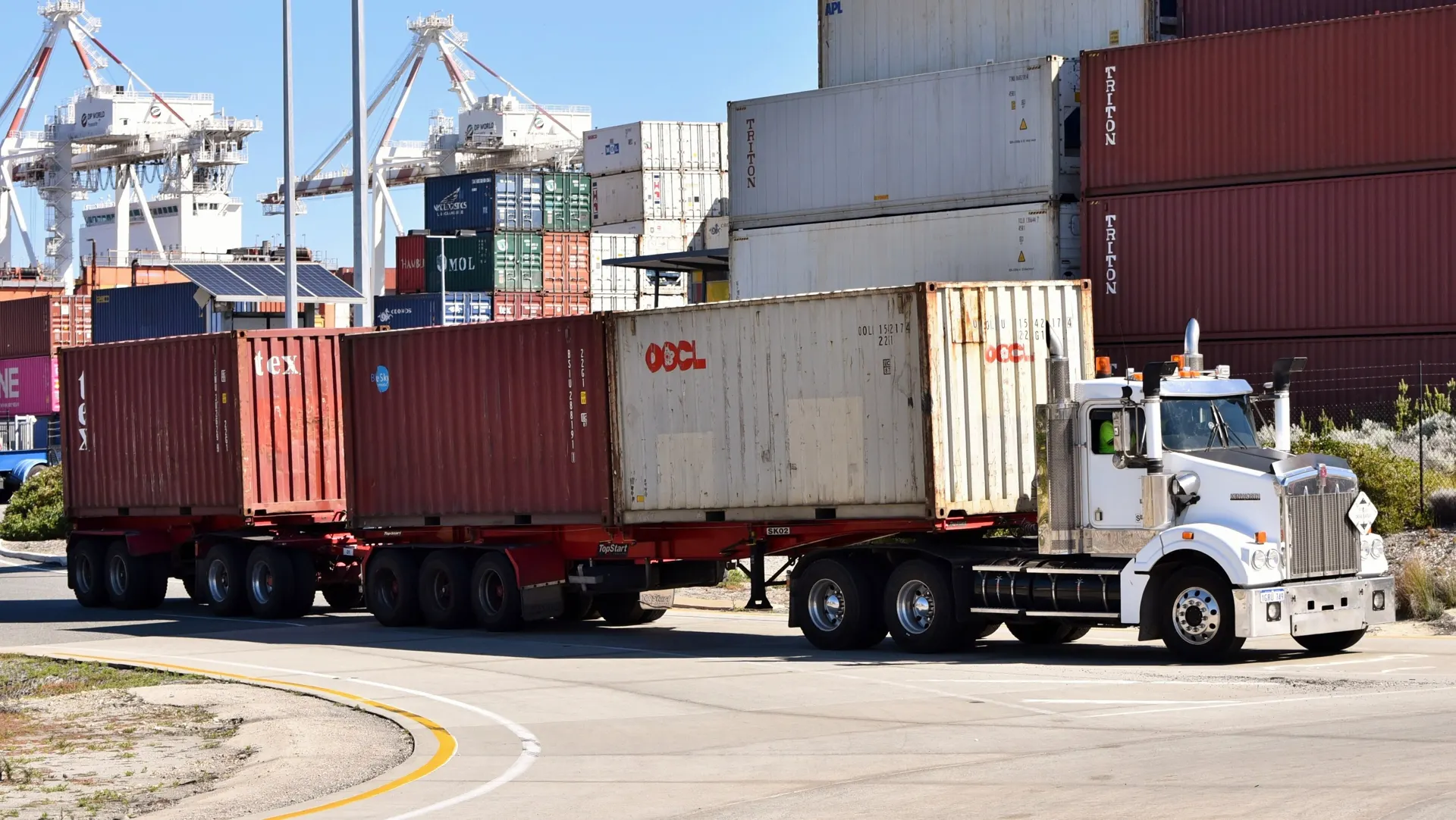 Truck hauling two containers at a port terminal